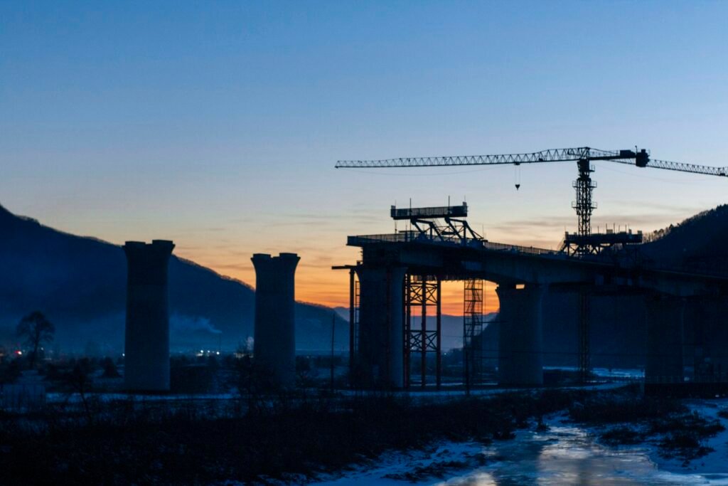 Bridge construction with a tower crane at dusk